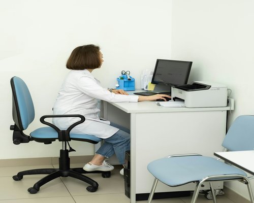 A person sitting at a desk and feeling fatigue in the body from a sedentary job.
